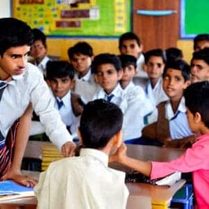a boy asking question to teacher in classroom